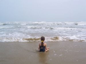 child-meditating-by-ocean