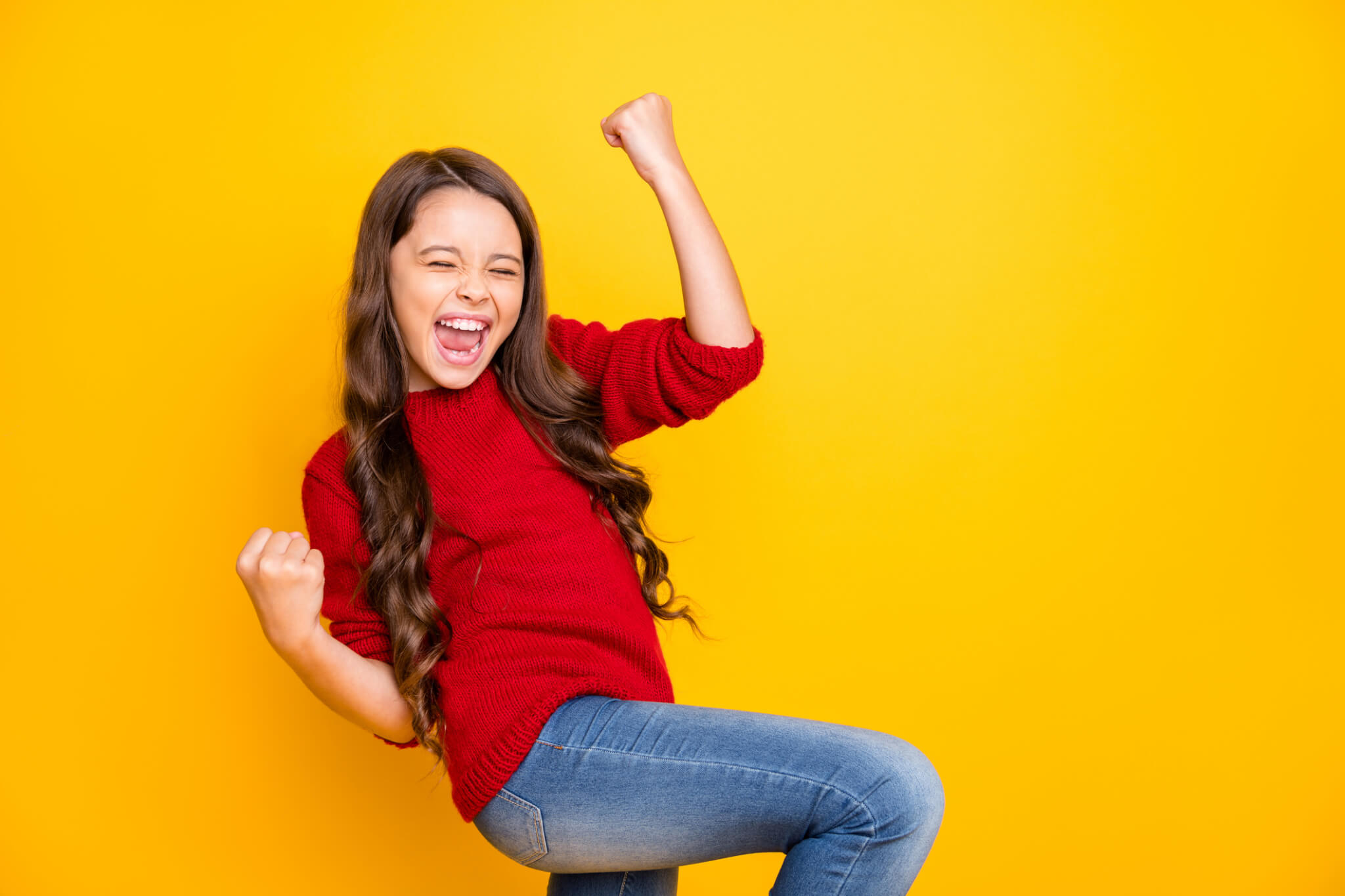 Portrait of delighted positive lucky cheerful kid feel crazy funky rejoice raise, fists scream yeah celebrate achievements aims wear style sweater denim jeans isolated over yellow color background